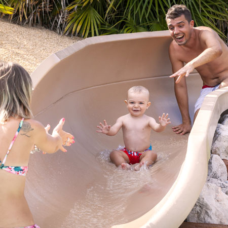 Un bambino molto piccolo è con mamma e papà nella Baby Lagoon.